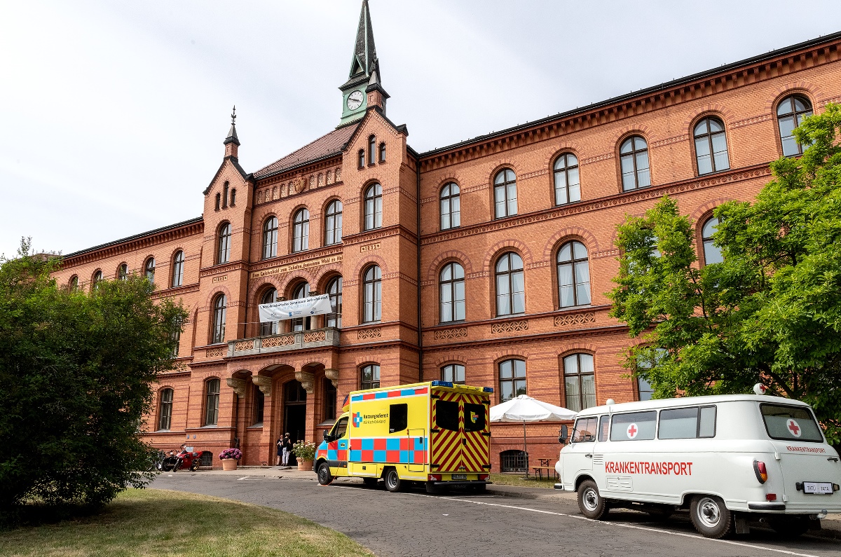 Krankenwagen aus unterschiedlichen Epochen stehen vor dem Verwaltungsgebäude des KEH.