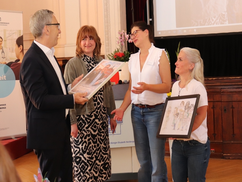 Pflegedirektor Uwe Kropp werden von drei Mitarbeiterinnen Geschenke überreicht.
