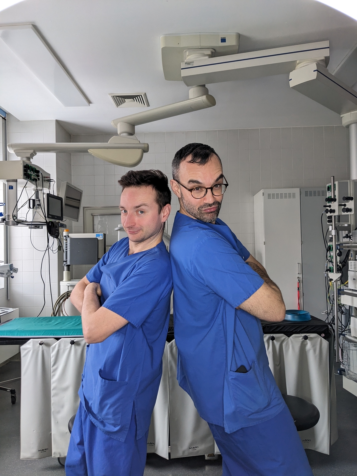 Zwei Internisten schauen Rücken an Rücken in die Kamera