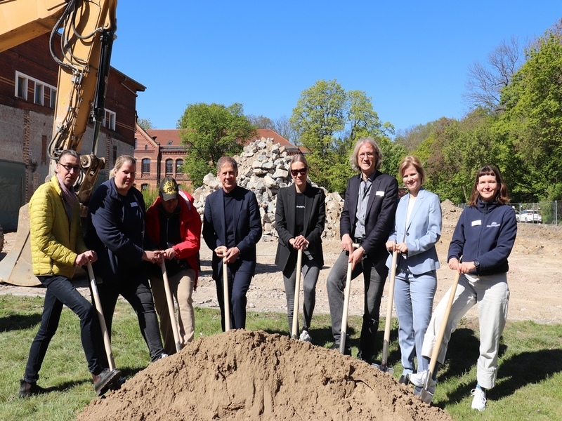 Mitarbeitende des Behandlungszentrums setzen gemeinsam mit dem Architektenteam den Spatenstich.
