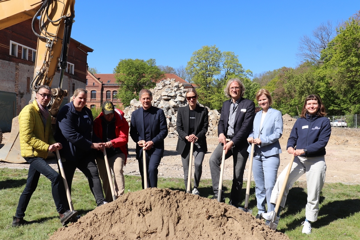 Mitarbeitende des Behandlungszentrums setzen gemeinsam mit dem Architektenteam den Spatenstich.